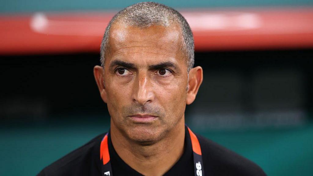 Close up of Sabri Lamouchi standing in the dugout looking focused